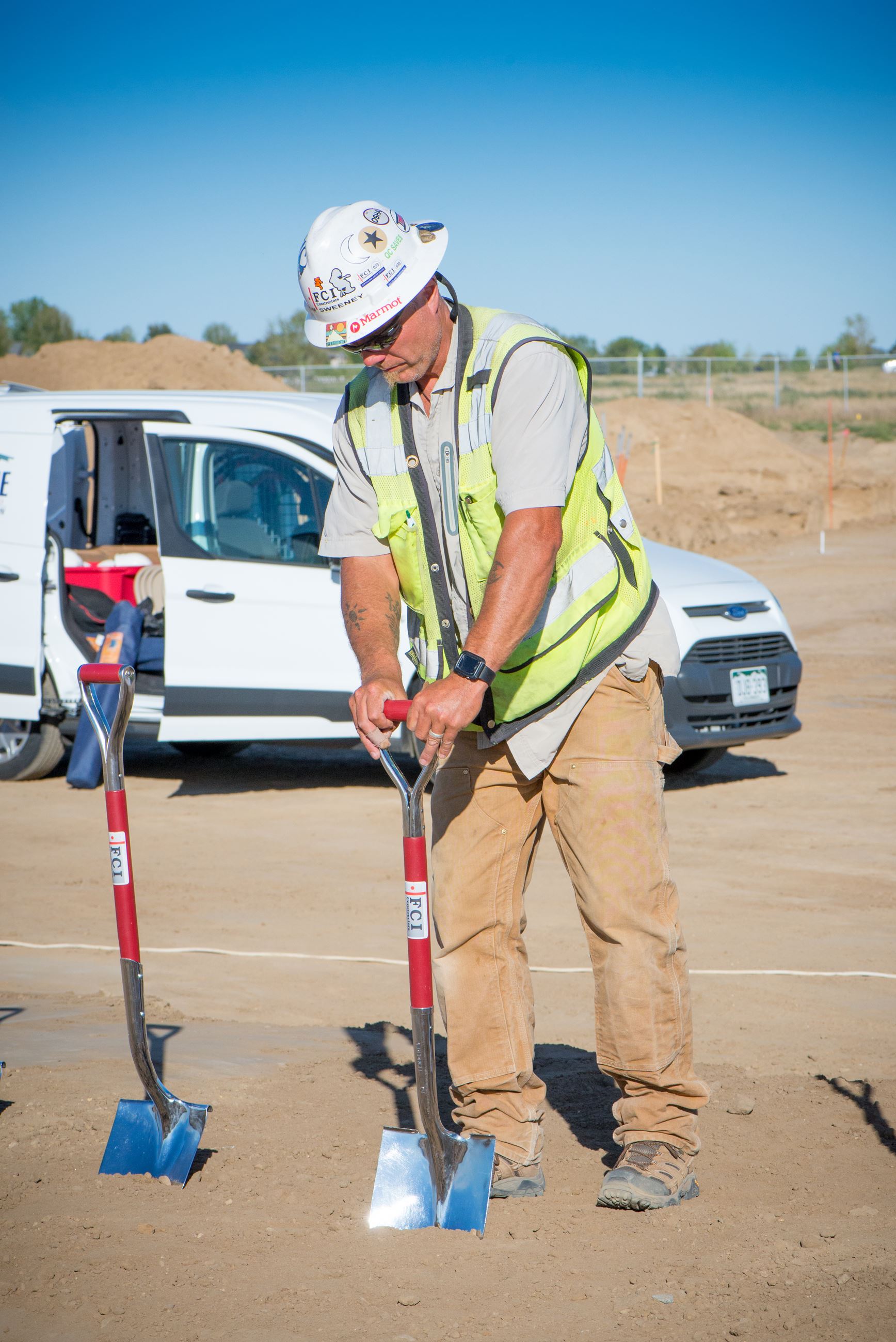 Firestone PD Groundbreaking picture of FCI worker putting in shovel in the ground